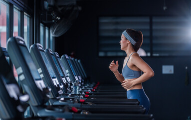 Fototapeta na wymiar Asian beautiful sport woman wearing sportwear with workout headband under exercise on treadmill machine gym is sport healthy body building in fitness lifestyle.