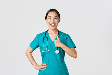 Covid-19, healthcare workers, pandemic concept. Smiling upbeat, confident female asian nurse in...