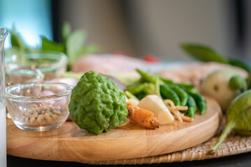 Focusing on bergamots are placed  among Thai spicies on wood circle plate.