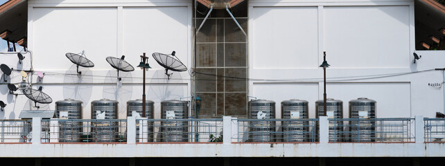 Water tanks and satellite dishes on the side of the building's exterior walls.