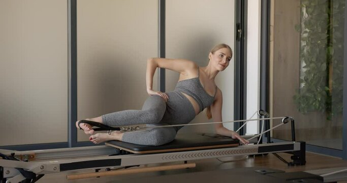 Pretty young pregnant model doing pilates on a machine
