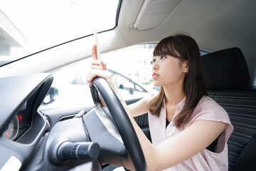 Driving woman using smartphone