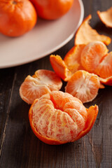 tangerines in white plate on wooden background