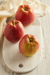 red apples on white plate on wooden table 