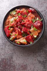 Delicious meat stew with beets and onions in a spicy sauce close-up in a bowl on the table. vertical top view from above