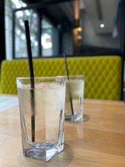 glass of water with ice and black paper straw