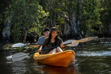 Foto op Canvas Asian attractive romantic young couple rowing kayak in a forest lake.  © Kawee