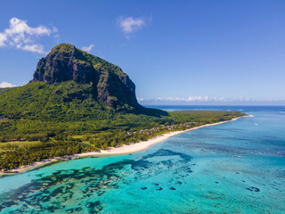 Strand von Le Morne Mauritius Tropischer Strand mit Palmen und weißem Sand, blauem Meer und Liegestühlen mit Sonnenschirmen, Liegestühlen und Sonnenschirmen unter einer Palme an einem tropischen Strand. Mauritius Le Morne