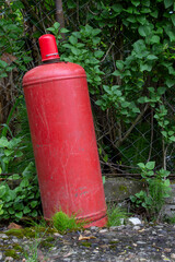 Red gas cylinder in the village. Rising gas prices. Saving gas consumption. Expensive gas.