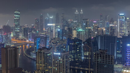 Skyline with modern architecture of Dubai business bay towers night timelapse. Aerial view