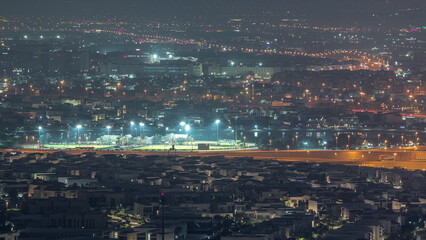 Aerial view of many apartment houses in Dubai city from above night timelapse