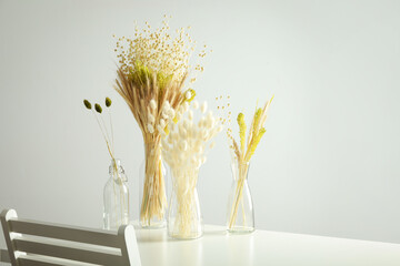 Hygge concept, dried flowers in vases on table