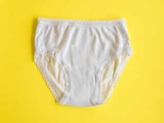 Underwear for children. White panties for girls on yellow, knitted cotton underwear