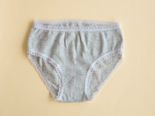 Underwear for children. Gray panties for girls on beige, knitted cotton underwear