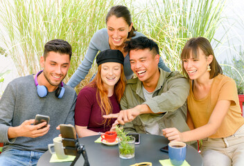 Glad multiracial friends having a video call in cafeteria