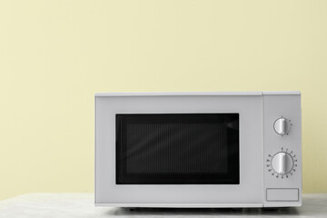 Obraz premium Microwave oven on table against color background