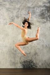 Graceful dancer leaping and looking at camera