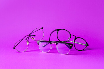 Stylish eyeglasses on purple background