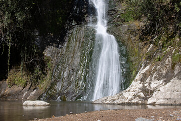 Fototapeta premium Beautiful and original panorama. Beautiful and majestic landscape and panorama of a mountain waterfall, a river, in textured and hard rocks and stones in the afternoon in the summer. High quality