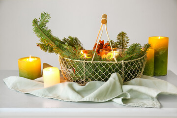 Obraz premium Burning candles and fir branches on table