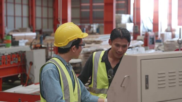 Engineering is on the job training apprentices of metal sheet roof ironing operation machine, two worker and engineer discussing and explaining detail at machine in factory, recruitment concept