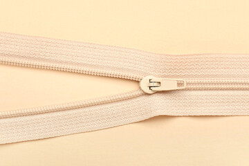 Stylish zipper on beige background