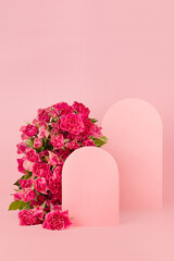 Spring pink flowers roses as rounded arch, two blank rounded spaces as podiums on abstract pink...