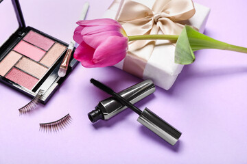 Obraz na płótnie Canvas Violet tulip, gift box and decorative cosmetics on color background