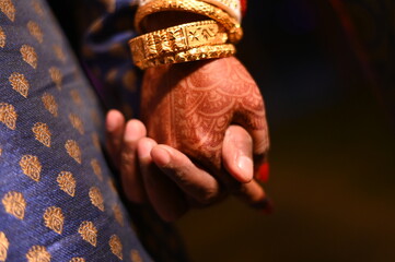 holding hands of a newly married Indian couple. 