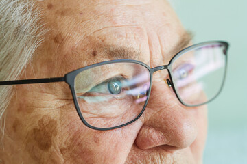 Close-up portrait in profile of an old woman in glasses