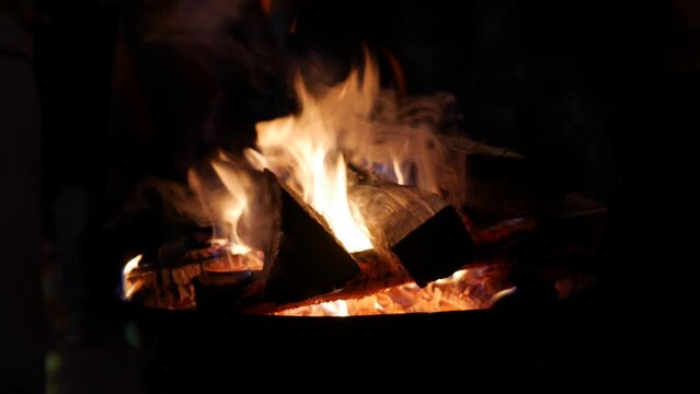 Burning pile of firewood at night. Bonfire at a family picnic. Close-up