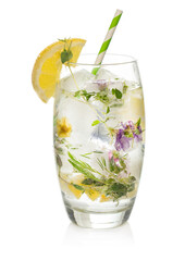 Cold sparkling water with ice and flowers decorated with slices of lemon