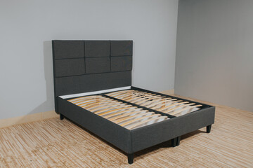 Bed with gray upholstery and wooden storage, without mattress