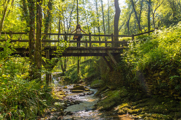 Obraz premium A mother with her son crossing a wooden bridge in the Pagoeta park in Aia, Guipuzcoa. Basque Country