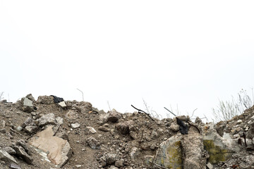 A mound of concrete rubble and construction debris against a gray sky. Background