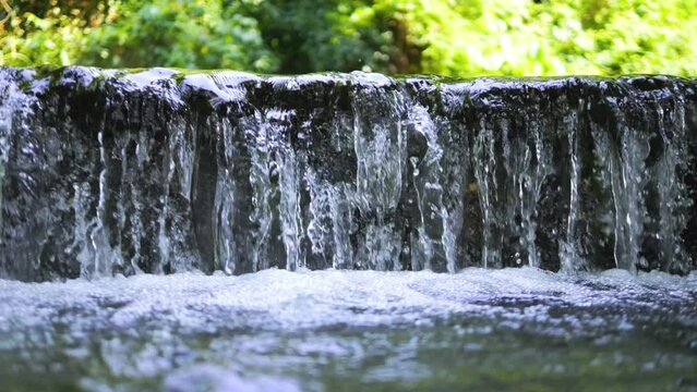 Beautiful waterfall with clear falling water in a rainforest shot in 4K in slow motion, Thailand. Natural outdoor eco tourism background concept.