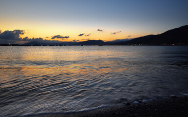 incredible colors and lights, a romantic sunset on the beach facing the sea in the magnificent Liguria