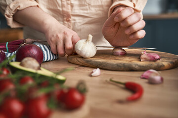 Obraz na płótnie Canvas Woman using fresh garlic in the kitchen