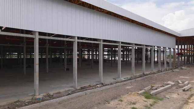 Rows of concrete pillars at unfinished large warehouse construction site. Architecture themes.