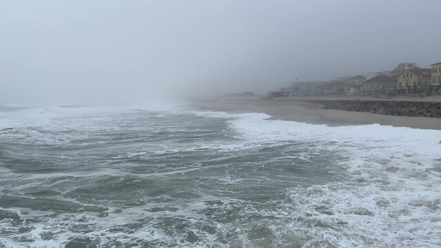 Waves, sea and coastal town of Furadouro, Atlantic ocean , Portugal. Grey foggy day