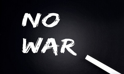 NO WAR Text on a Black Chalkboard with a piece of chalk