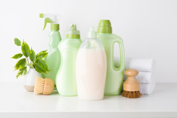 Eco cleaning products and brushes on table and white background