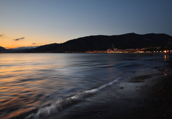 incredible colors and lights, a romantic sunset on the beach facing the sea in the magnificent Liguria