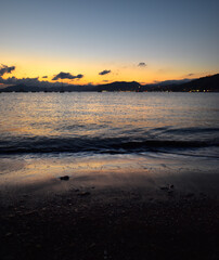 incredible colors and lights, a romantic sunset on the beach facing the sea in the magnificent Liguria