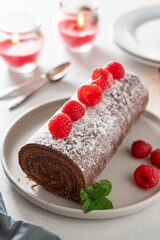 Chocolate roll cake or swiss dessert cake with raspberries