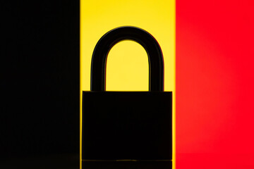 Silhouette of lock in front of flag of Belgium. Concept of closed country, isolation from the world, restrictions