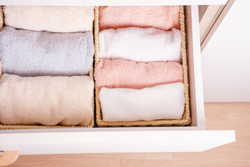 Folded towels in closet close-up, space organization concept.