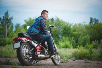 Fototapeta na wymiar Motorcyclist is sitting on the motorbike outdoors.
