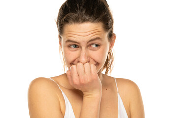 Embarrassed young woman laughing and covering mouth with hand on a white background