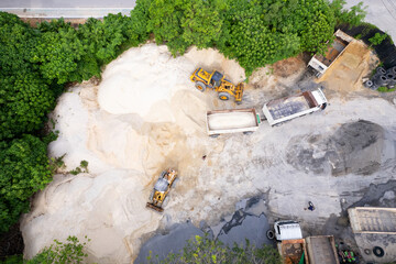 Drone view over sand quarry with heavy machinery.The truck and excavator.The truck drives up to the excavator for sand and crushed stone loading